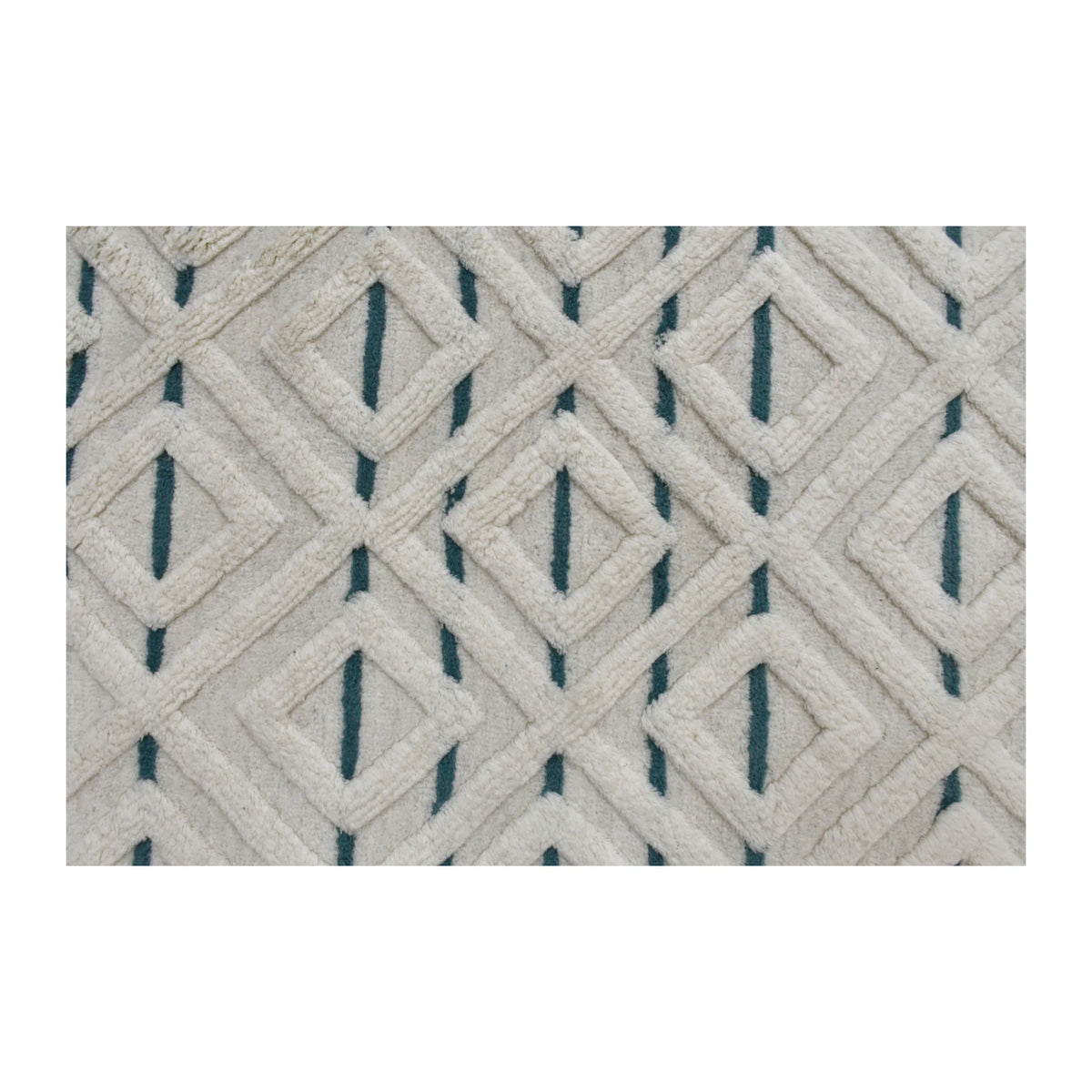 Field detail of cream wool rug showing an interlocking raised diamond lattice with muted blue geometric accents