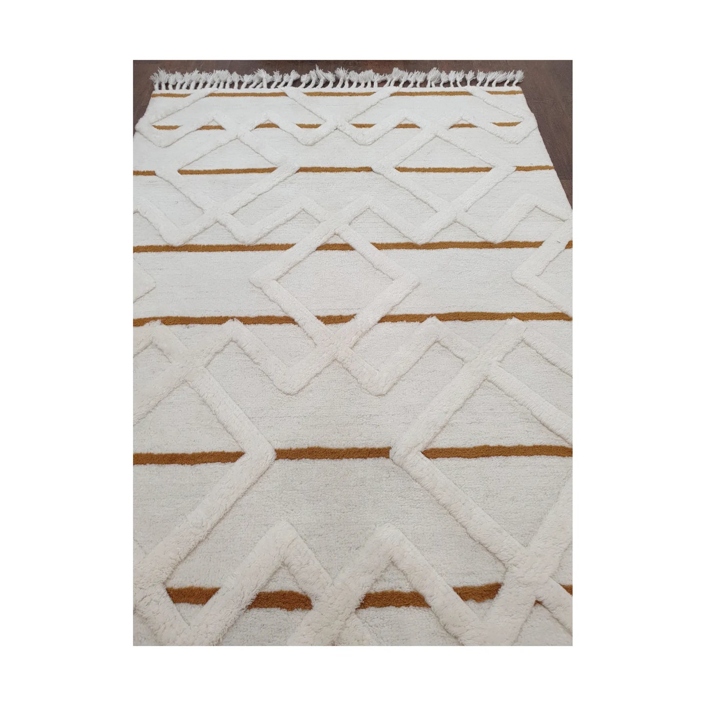 Low-angle close-up of cream mustard hand-tufted wool rug showing texture and edge detail