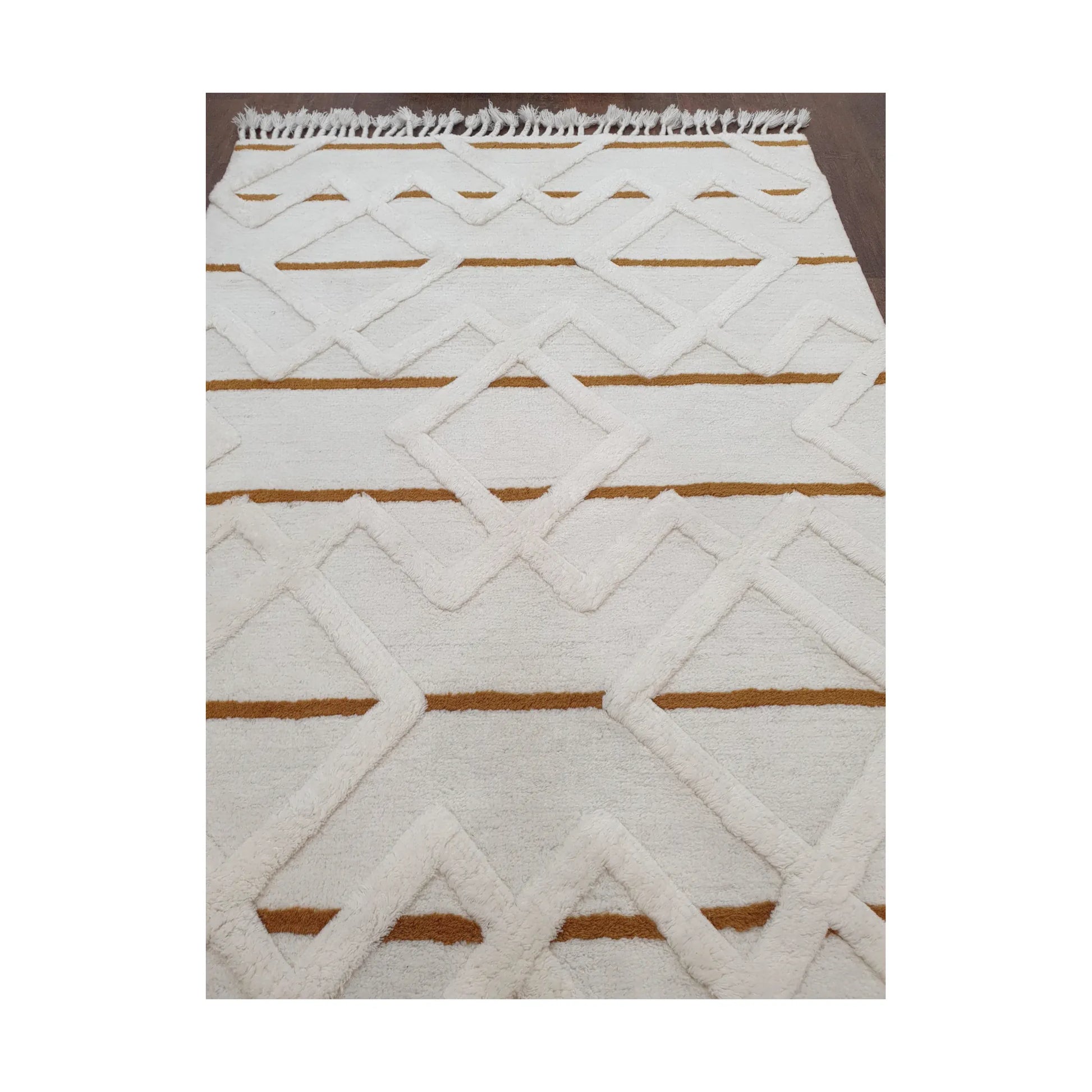 Low-angle close-up of cream mustard hand-tufted wool rug showing texture and edge detail