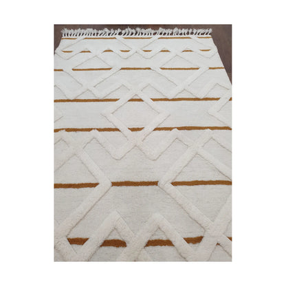 Low-angle close-up of cream mustard hand-tufted wool rug showing texture and edge detail