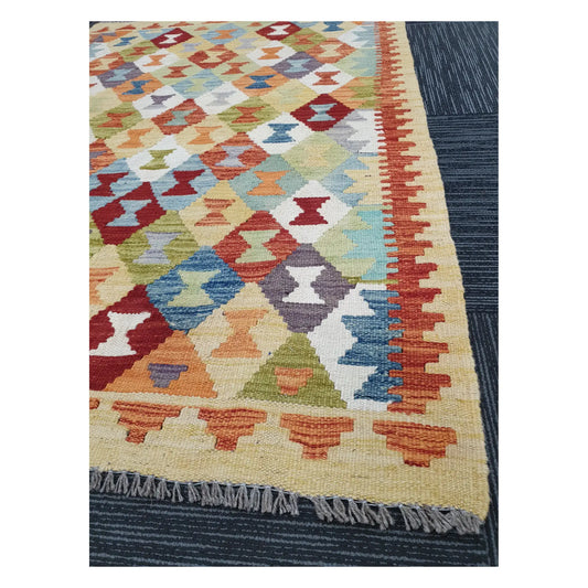 Angled detail of Afghan Chobi Kilim showing fringe, warm border pattern, and handwoven flatweave texture, 137 x 100 cm