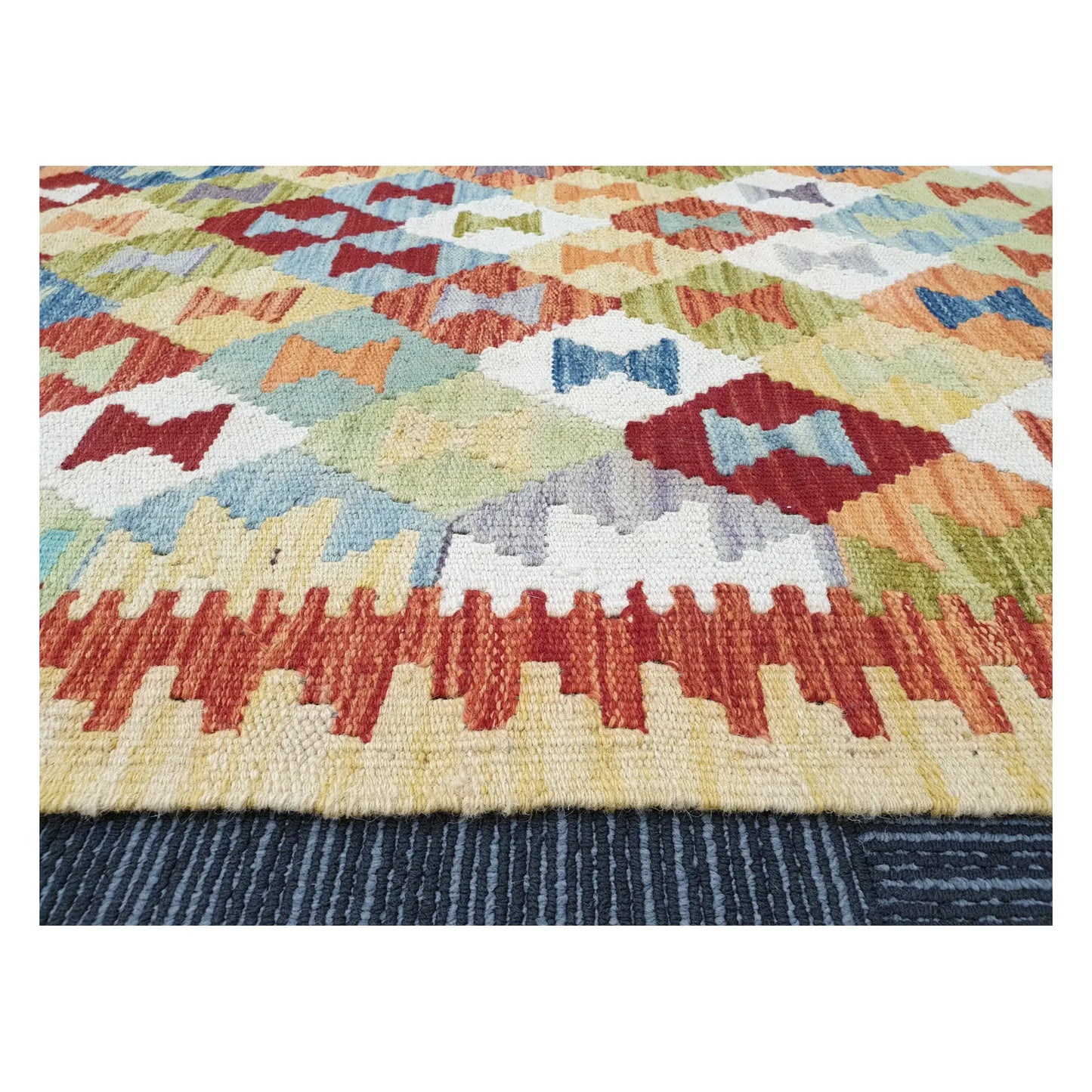 Low-angle close-up of Afghan Chobi Kilim showing wool flatweave texture and multicolour geometric pattern, 137 x 100 cm