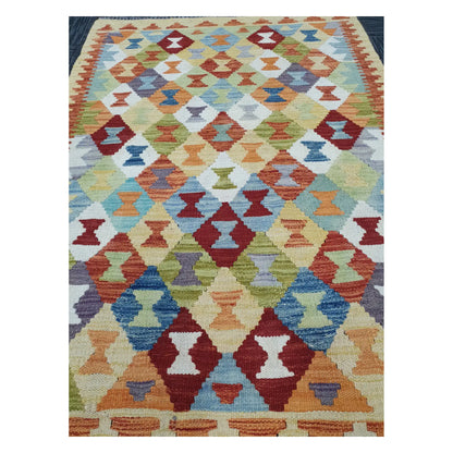 Close-up of Chobi Kilim rug with small diamond motifs in mustard, blue, sage, terracotta, and burgundy, 137 x 100 cm