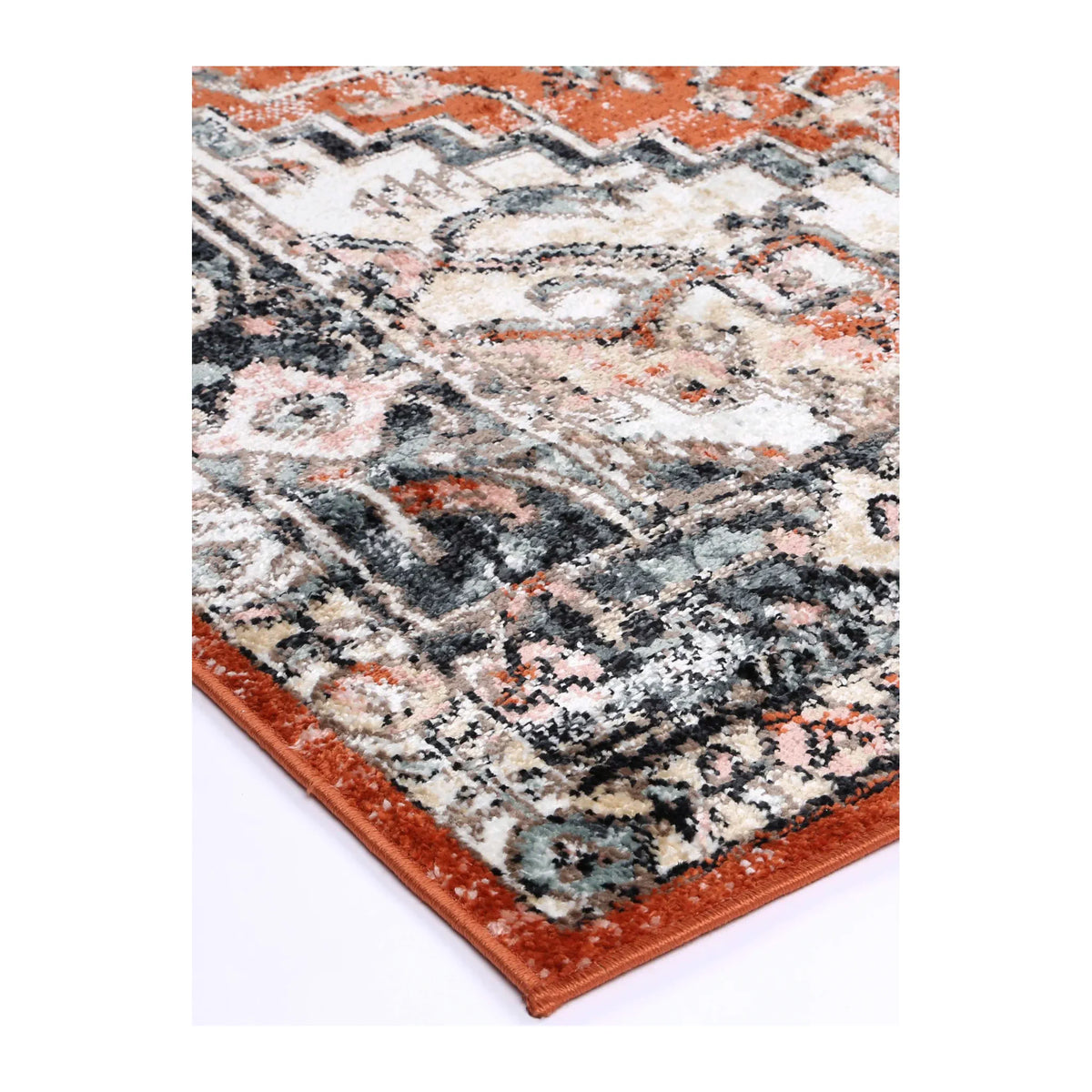 Angled corner detail of Estate Terracotta rug showing the bound edge, layered border and patterned polypropylene pile