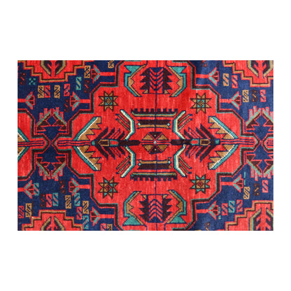 Central motif detail of Baluchi wool rug with deep red, teal, ochre and ivory patterning