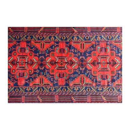Field detail of Afghan Baluchi rug showing mirror-balanced floral-geometric motifs in red and dark navy