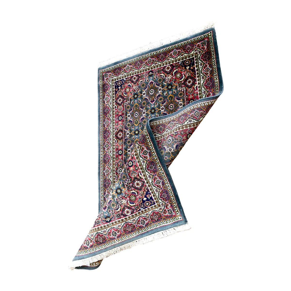 Folded view of Fine Bidjar rug showing its blue-grey floral front, muted red borders and exposed patterned reverse