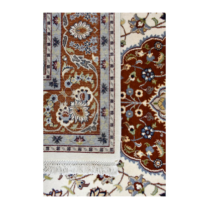 Folded-corner close-up showing the Fine Tabriz rug’s patterned reverse and white fringe beside its rust-red medallion