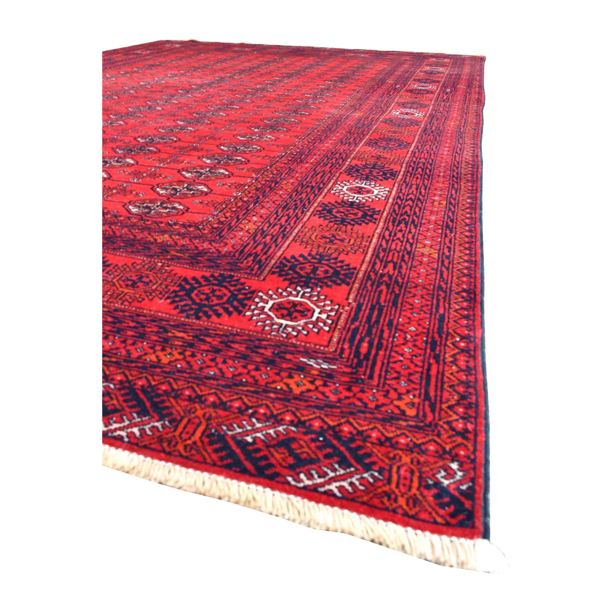 Angled view along the Fine Turkmen Tekke rug showing its red gül field, layered dark borders and pale fringe