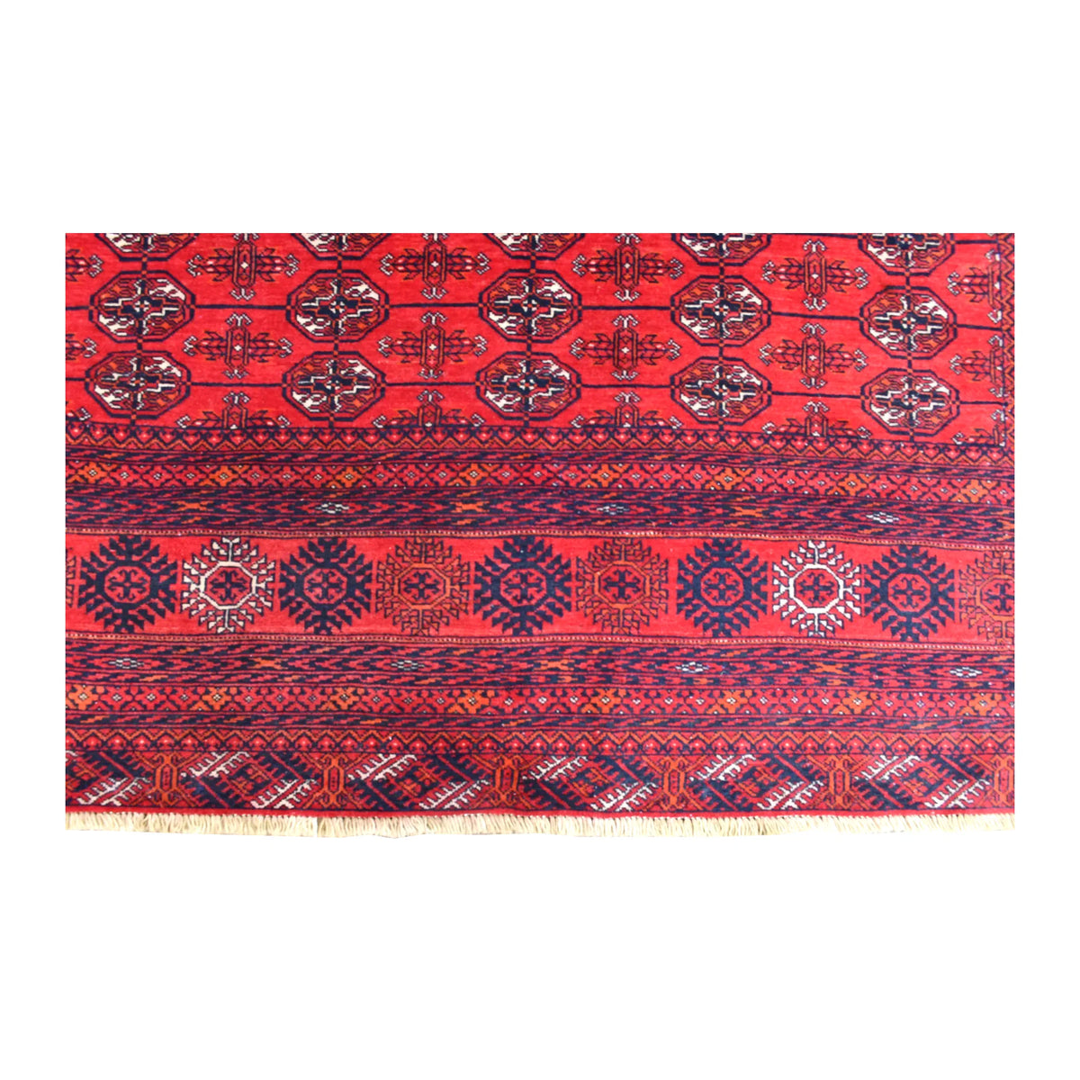 Fringed end of the Fine Turkmen Tekke rug showing rows of guls above rosettes and narrow geometric border bands