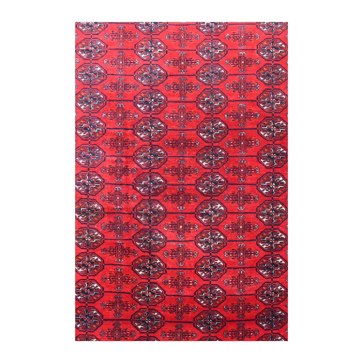 Field detail of the Fine Turkmen Tekke rug showing repeated dark guls and smaller motifs across the red wool pile