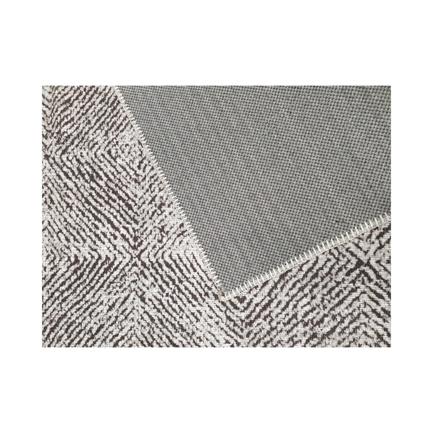 Close-up of grey charcoal cotton rug corner with back and edge detail