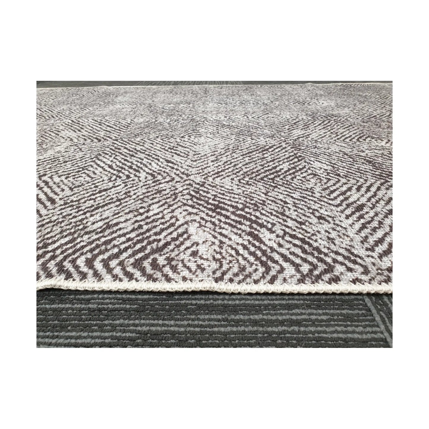 Low-angle close-up of grey charcoal cotton rug edge and woven texture
