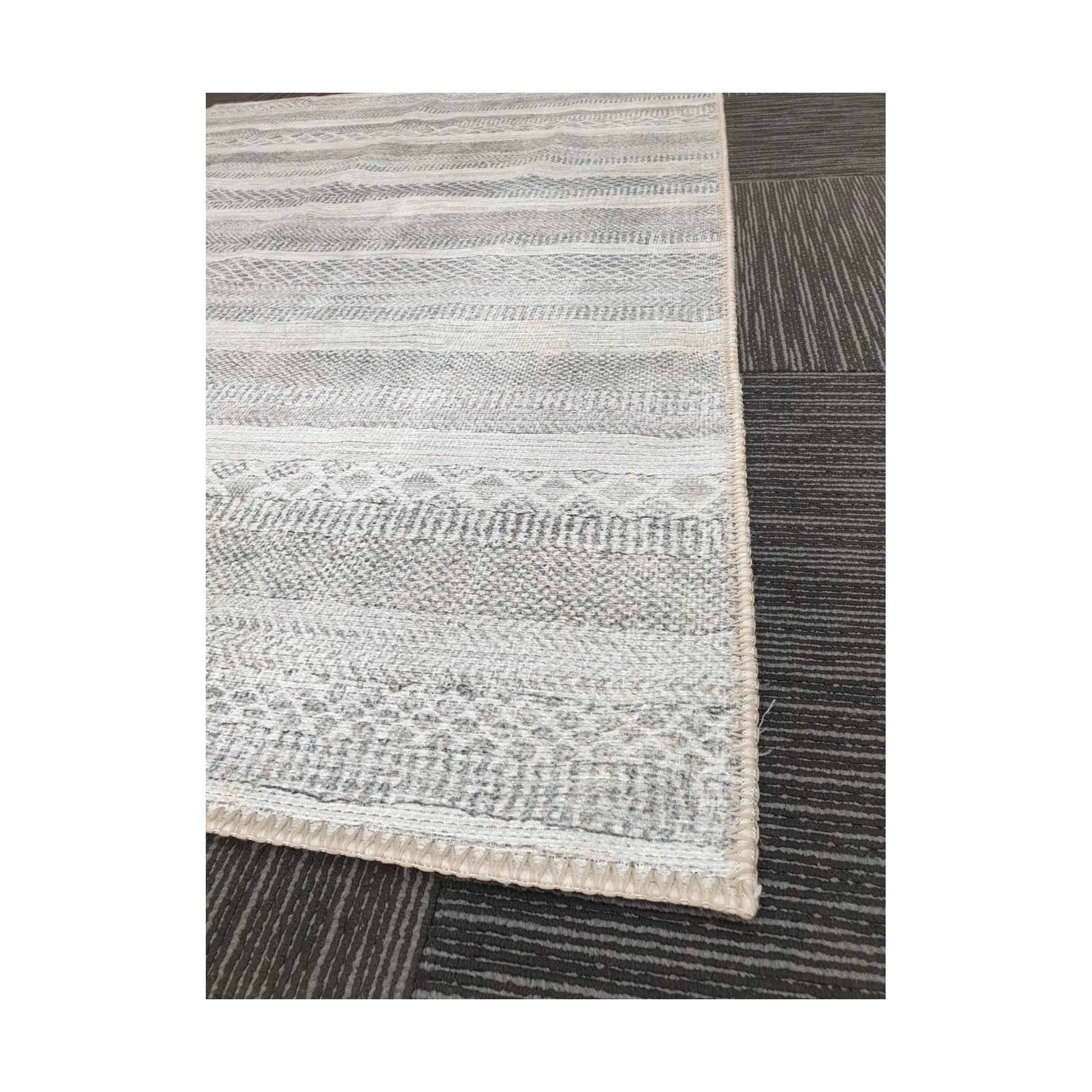 Close-up of grey ivory geometric stripe cotton rug corner and border detail