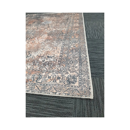 Close-up of grey rust cotton rug corner with faded ornamental border detail