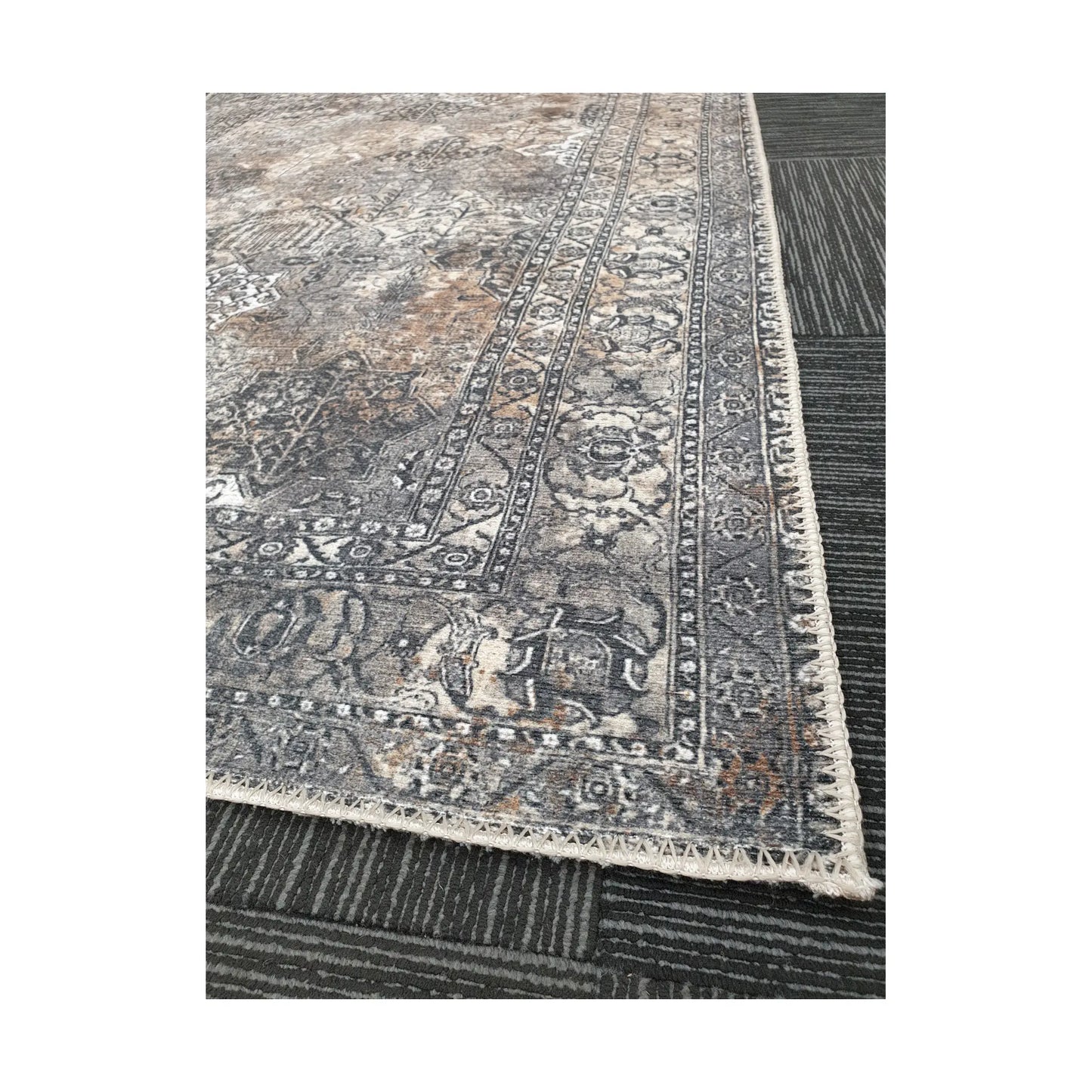 Close-up of grey silver cotton rug corner with ornamental border detail