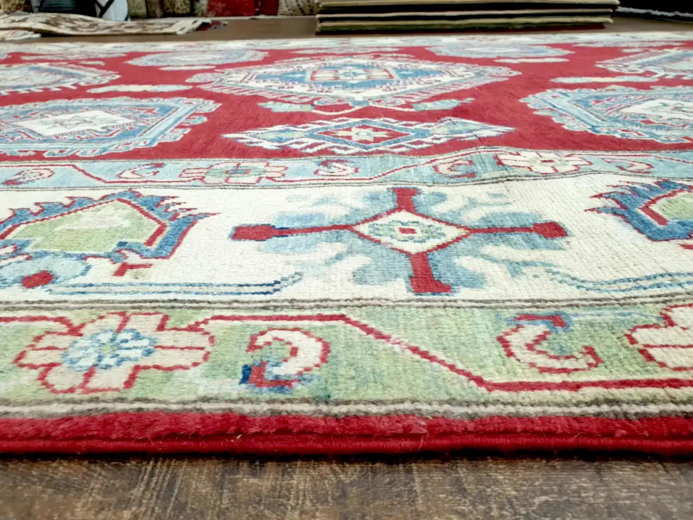 Border detail of hand-knotted Kazak rug with traditional geometric motifs