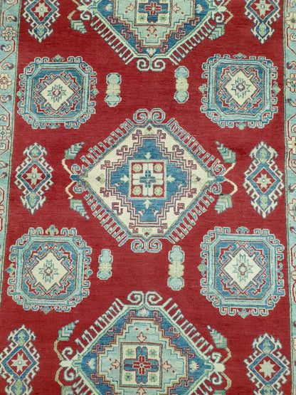 Top view of Kazak rug with red, cream and blue geometric medallions