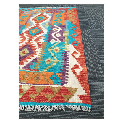 Angled detail of Afghan Chobi Kilim showing fringe, geometric border, and multicolour flatweave pattern, 113 x 89 cm