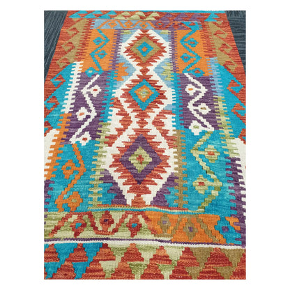 Close-up of Chobi Kilim rug with stacked diamond motifs in turquoise, plum, rust orange, and ivory, 113 x 89 cm