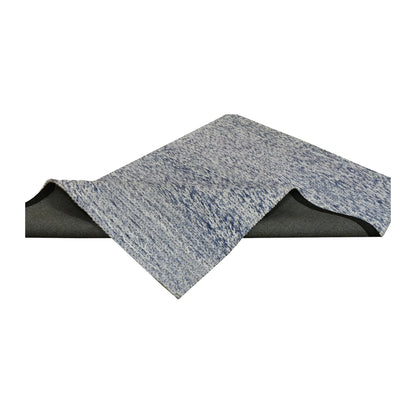 Folded view of Harlow blue hand-tufted wool rug showing its textured surface, finished edges and dark backing