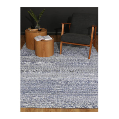 Lifestyle view of Harlow blue wool rug in a modern seating area, 230 x 160 cm