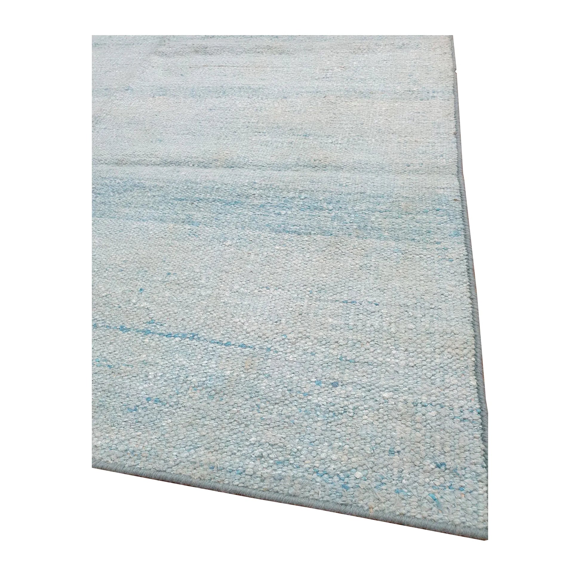 Edge detail of Indian Dhurrie rug showing pale blue woven texture and fine horizontal striations