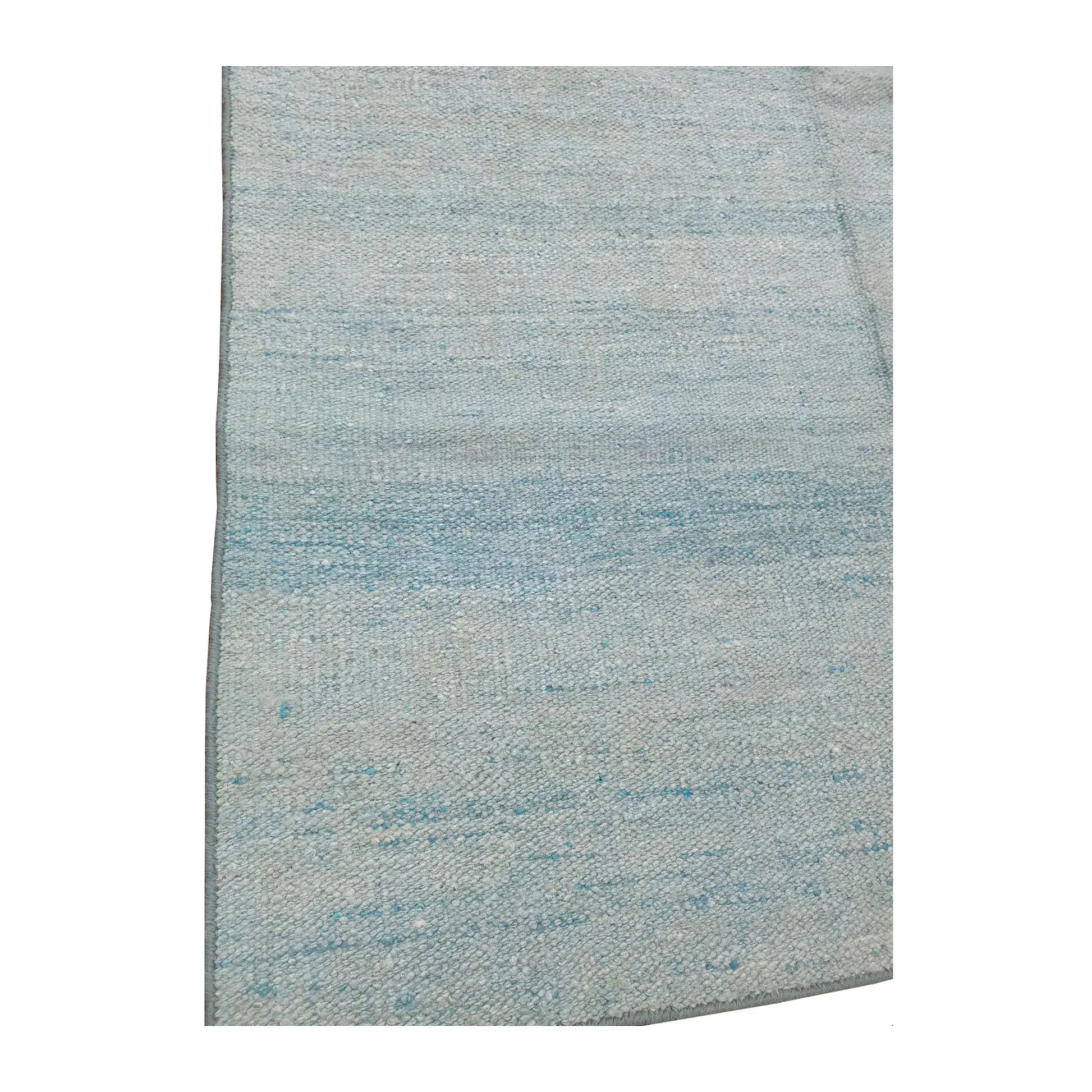 Close-up of Indian Dhurrie rug showing light blue and off-white tonal bands across the flatwoven surface