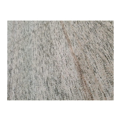Close-up of Indian Dhurrie rug showing irregular charcoal and beige striations across an off-white woven surface