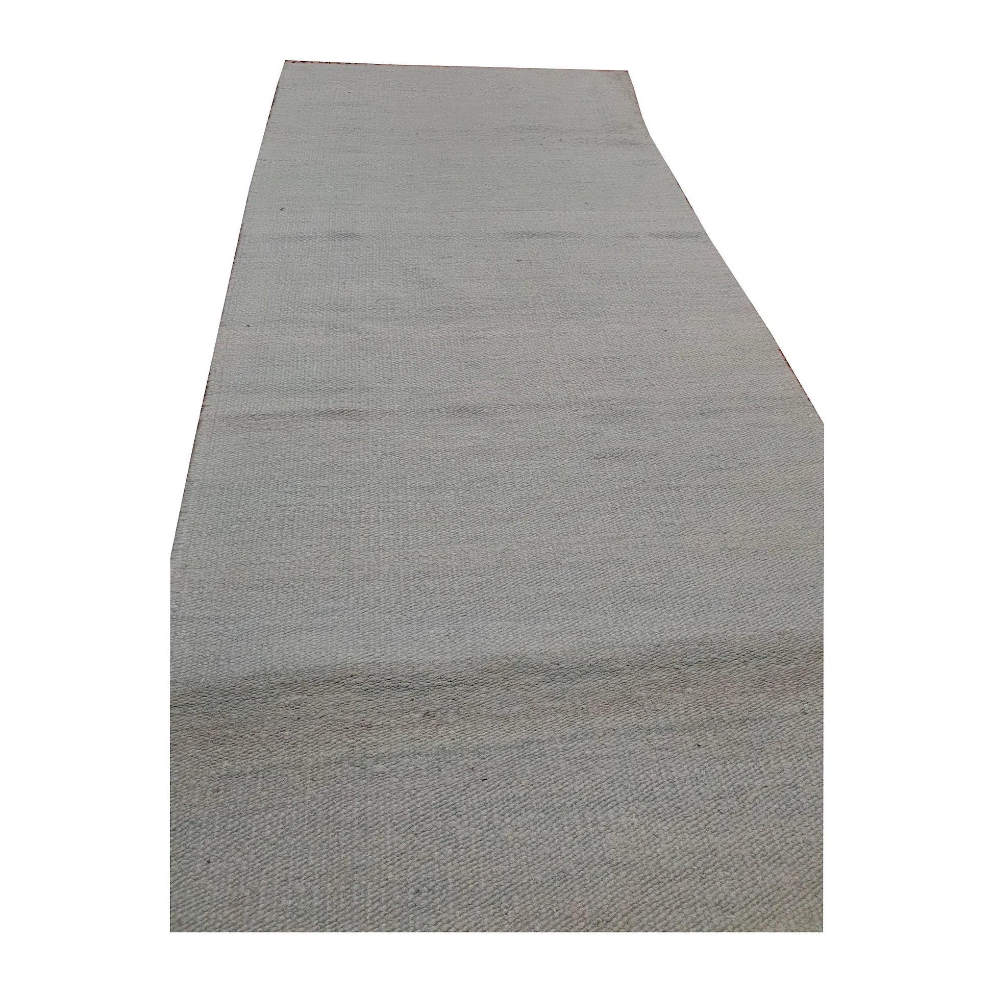 Close-up of Indian Dhurrie runner showing soft green-blue tonal bands across the off-white woven surface