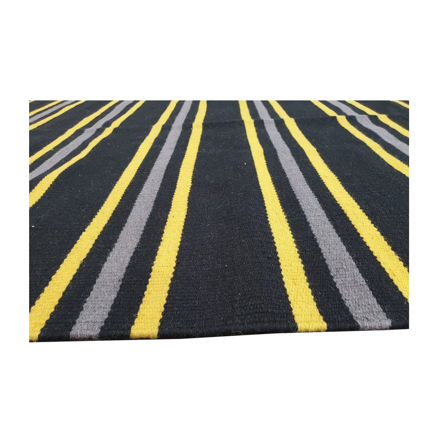 Low-angle close-up of Indian Dhurrie fine wool rug showing striped flatweave texture in charcoal, yellow, and grey, 230 x 160 cm