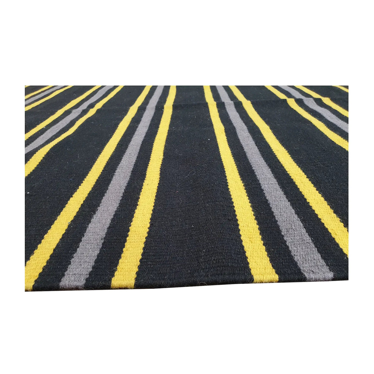 Low-angle close-up of Indian Dhurrie fine wool rug showing striped flatweave texture in charcoal, yellow, and grey, 230 x 160 cm