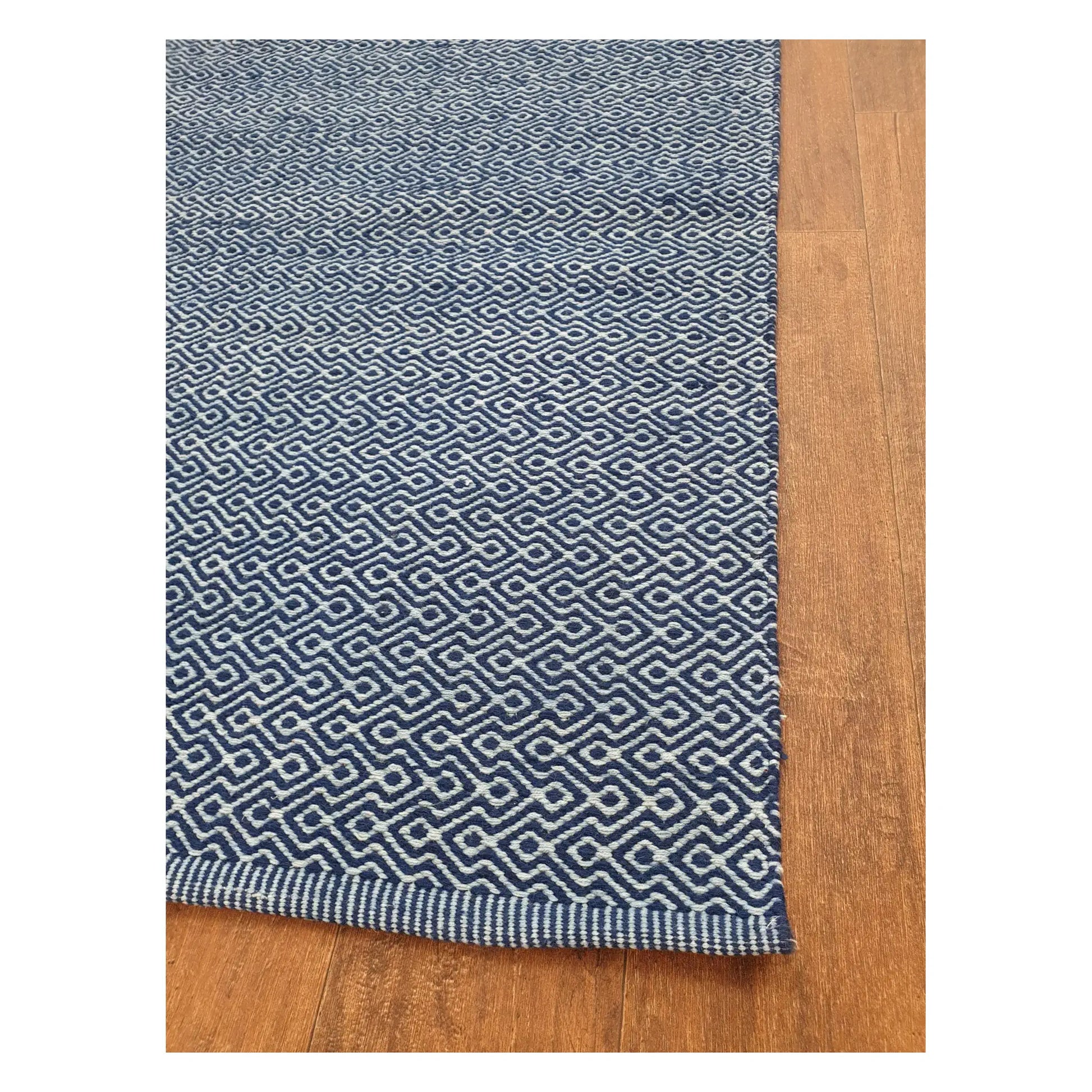 Angled edge detail of Indian Dhurrie showing blue woven geometric pattern and flatweave texture, 230 x 160 cm