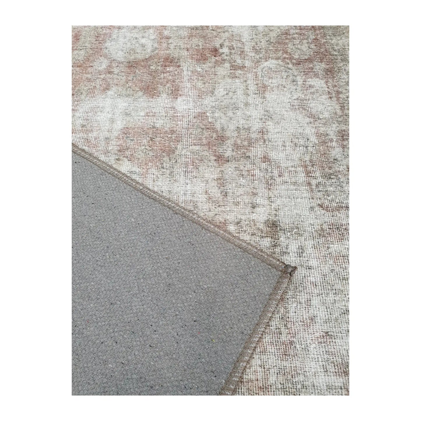Close-up of ivory blush cotton rug corner with back and edge detail