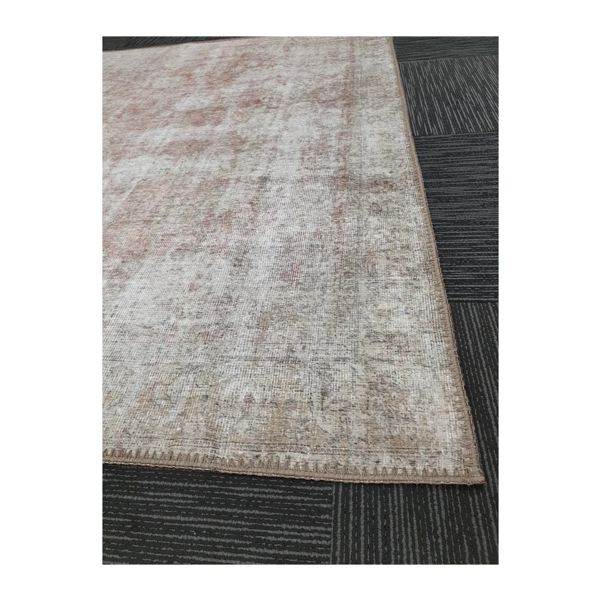 Close-up of ivory blush cotton rug corner with soft abstract pattern and edge detail