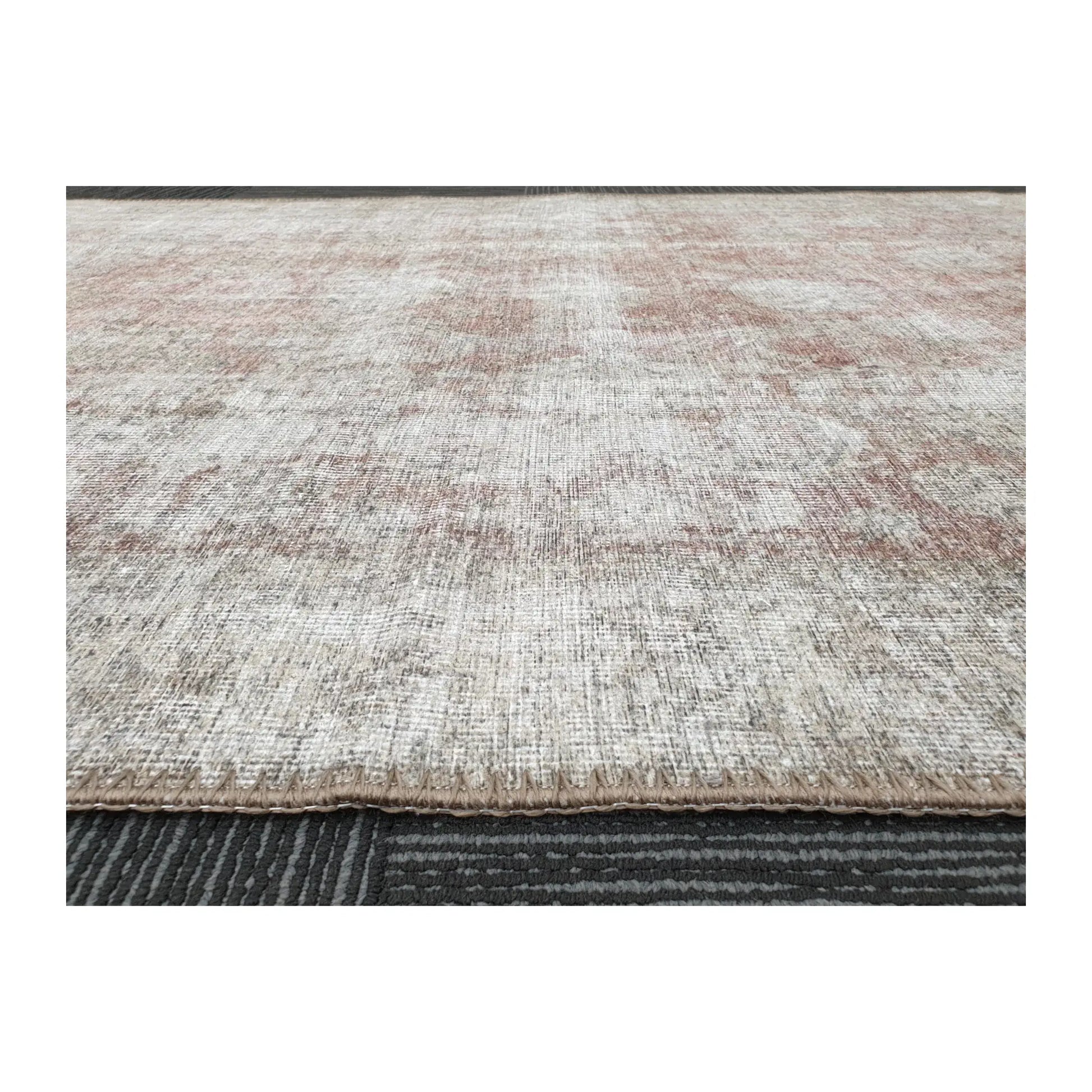 Low-angle close-up of ivory blush cotton rug edge and woven surface texture