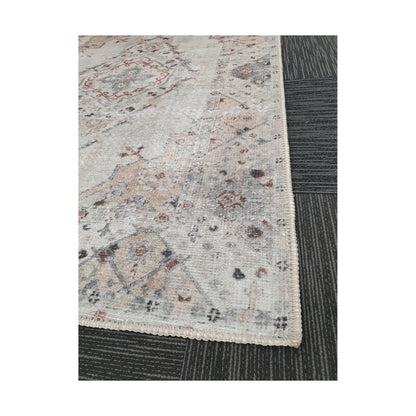 Close-up of ivory blush cotton rug corner with faded floral border detail