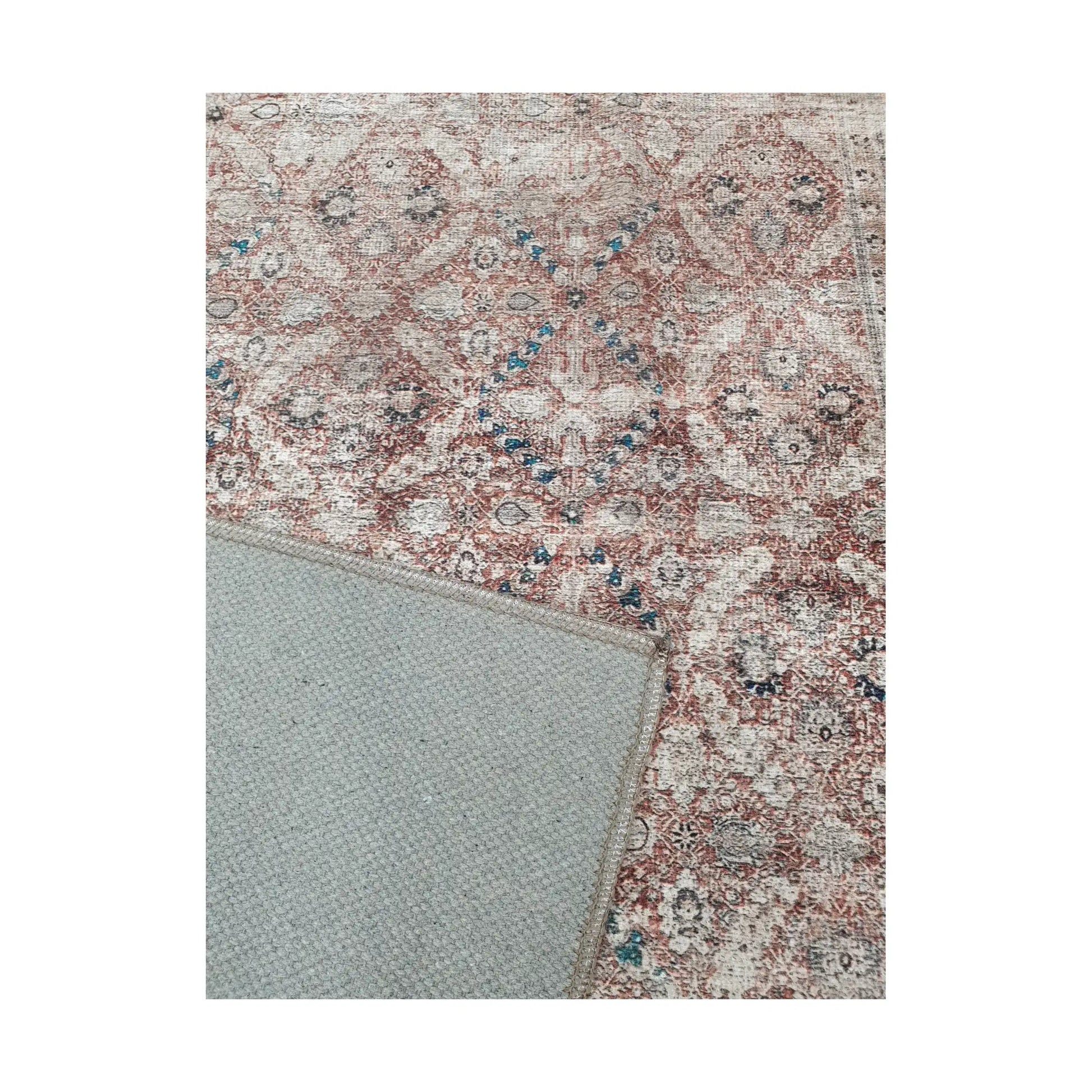Close-up of ivory blush teal cotton rug corner with back and edge detail