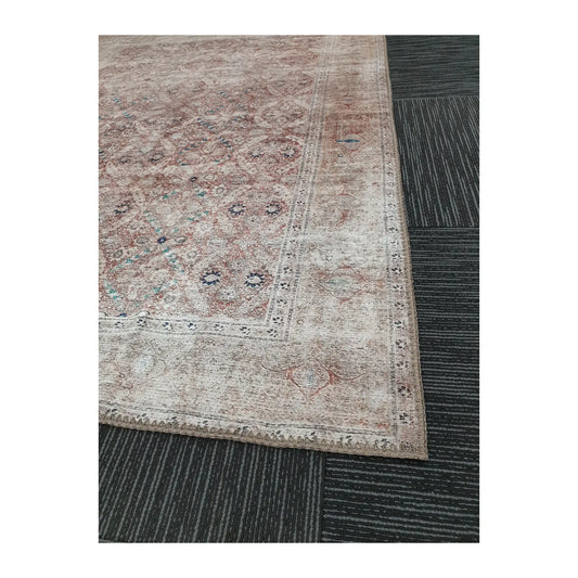 Close-up of ivory blush teal cotton rug corner with faded border detail