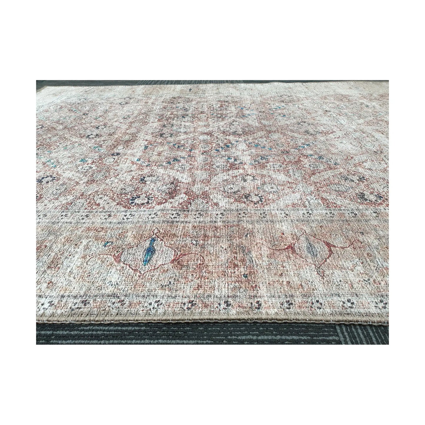 Low-angle close-up of ivory blush teal cotton rug edge and woven surface texture