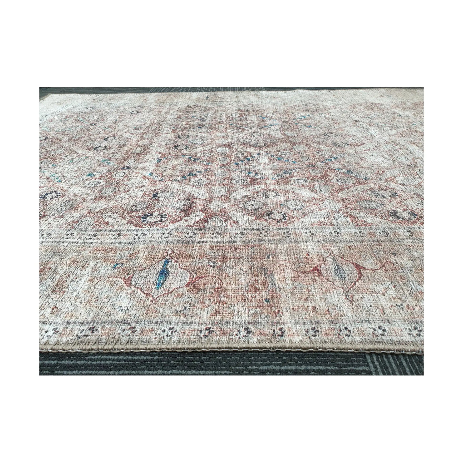 Low-angle close-up of ivory blush teal cotton rug edge and woven surface texture