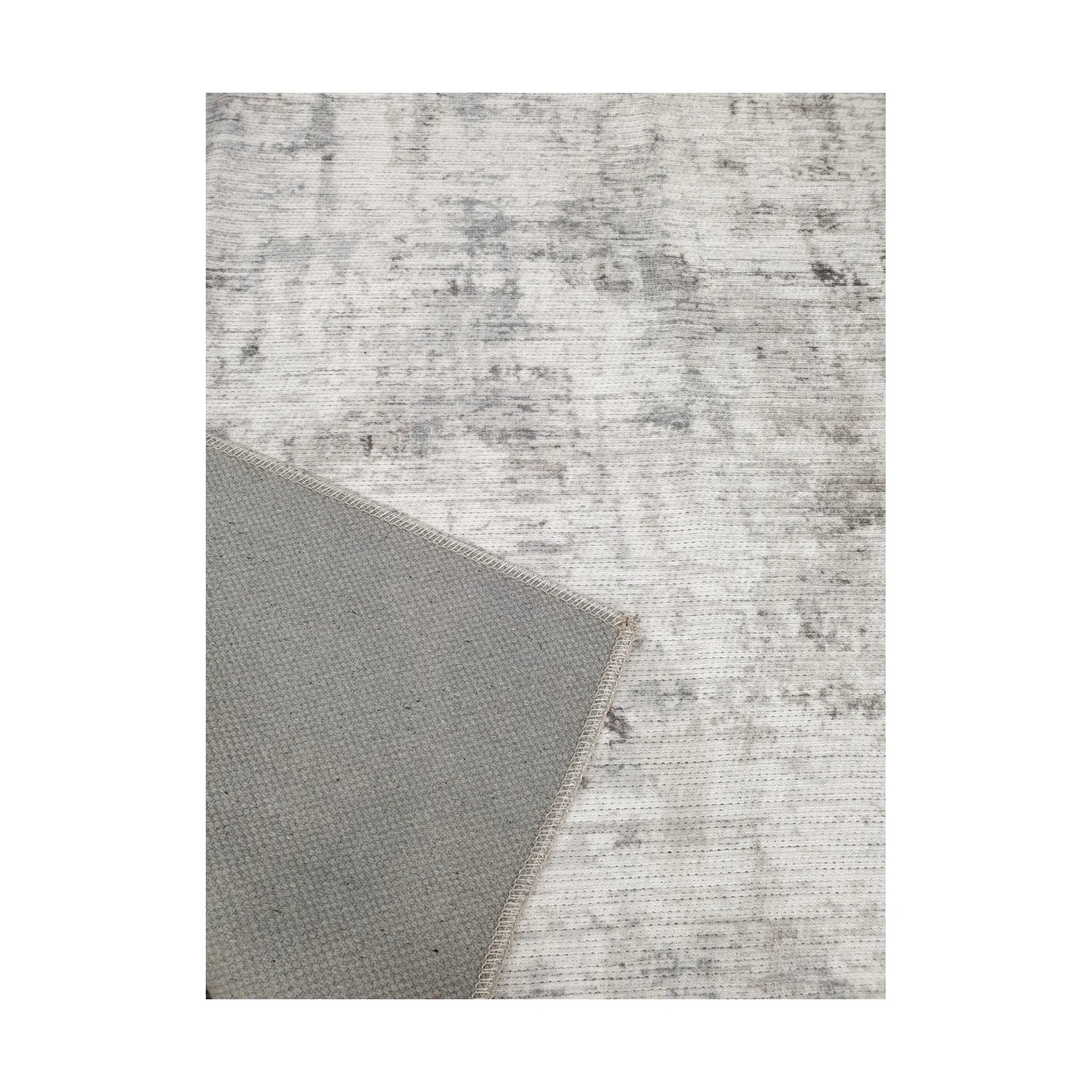 Close-up of ivory grey cotton rug corner with back and edge detail