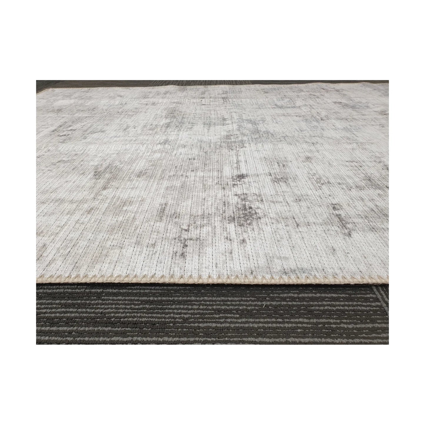 Low-angle close-up of ivory grey cotton rug edge and woven surface texture