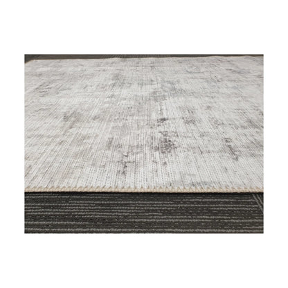 Low-angle close-up of ivory grey cotton rug edge and woven surface texture