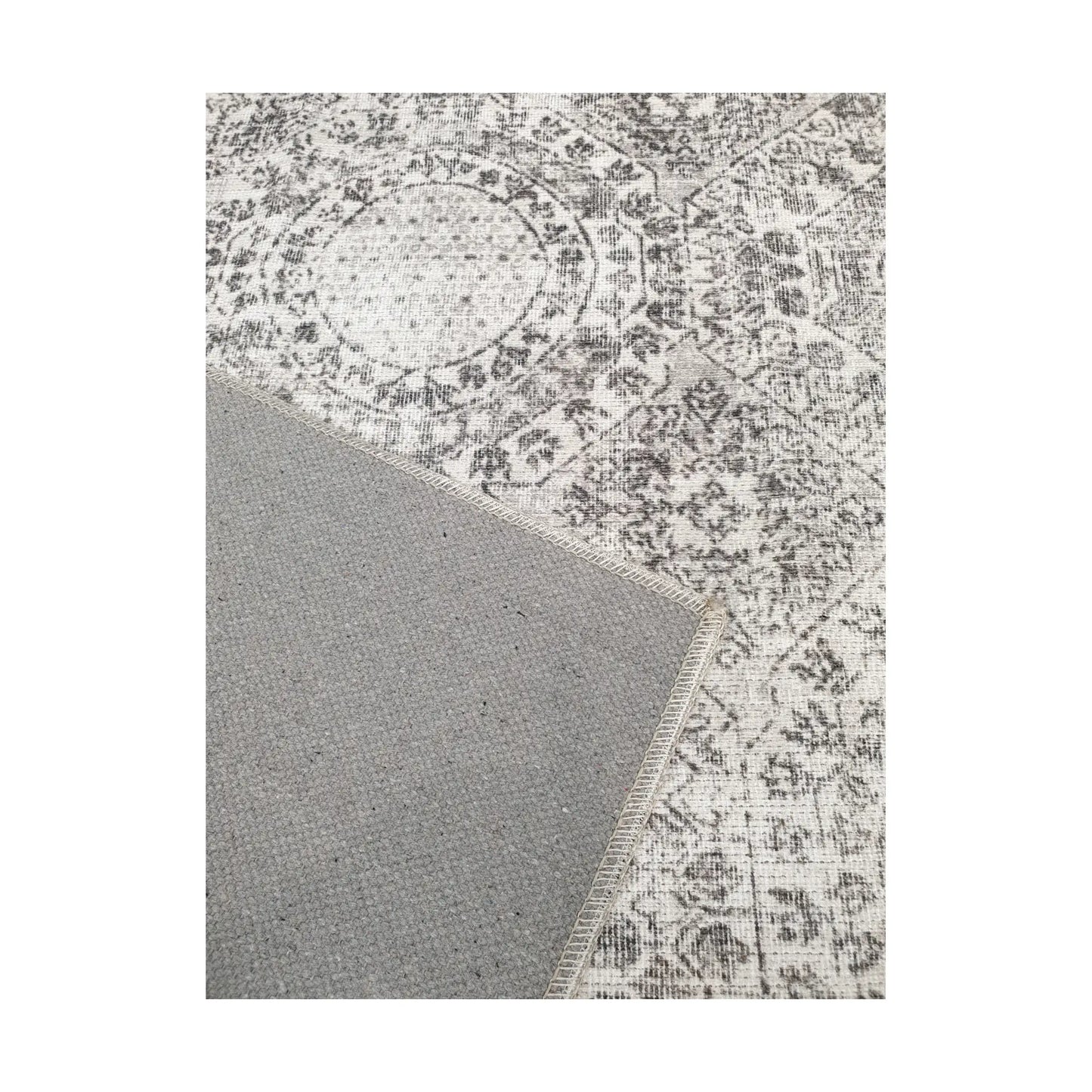 Close-up of ivory grey cotton rug corner with back and edge detail