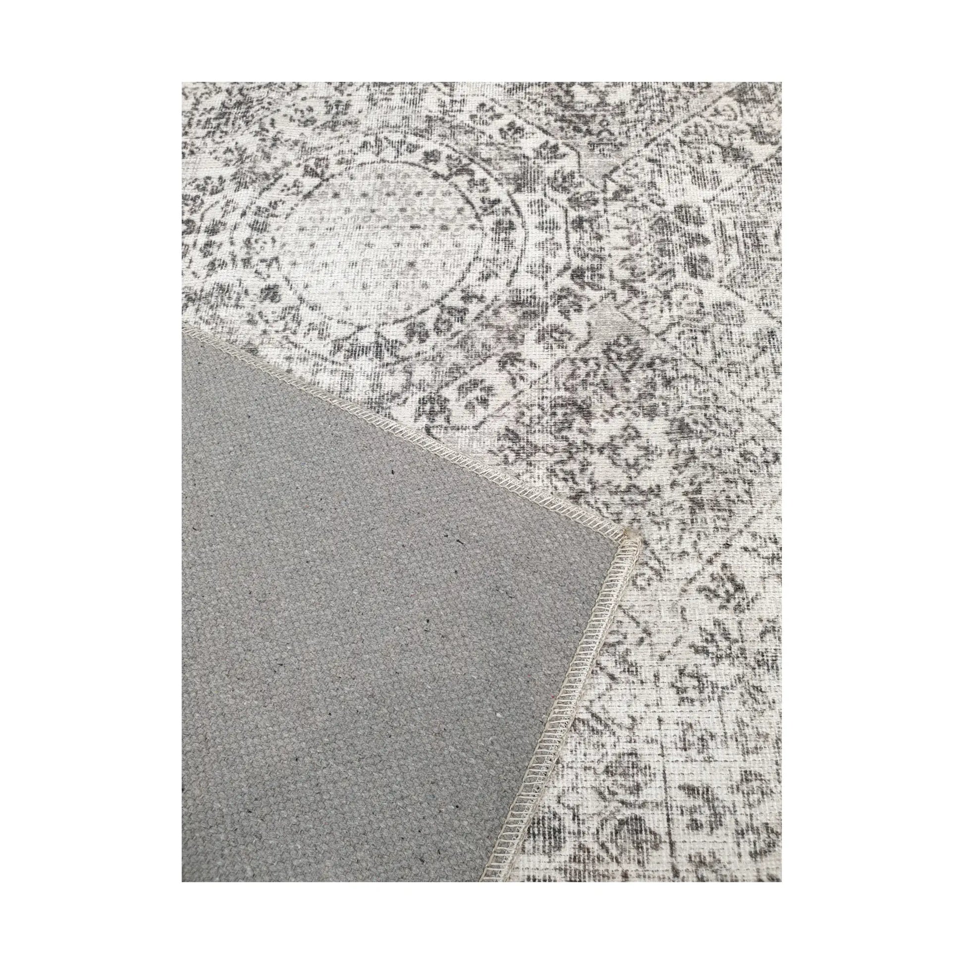 Close-up of ivory grey cotton rug corner with back and edge detail