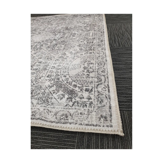 Close-up of ivory grey cotton rug corner with floral border detail