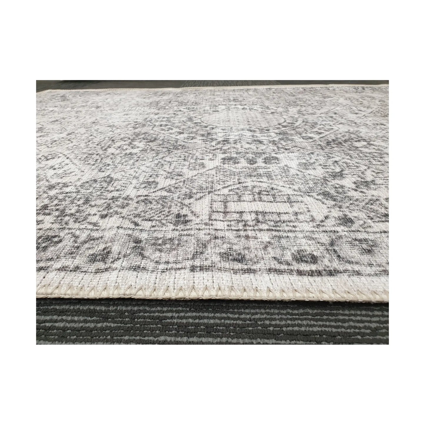 Low-angle close-up of ivory grey cotton rug edge and woven surface texture