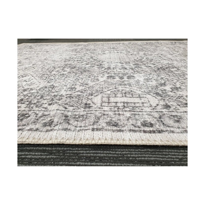 Low-angle close-up of ivory grey cotton rug edge and woven surface texture