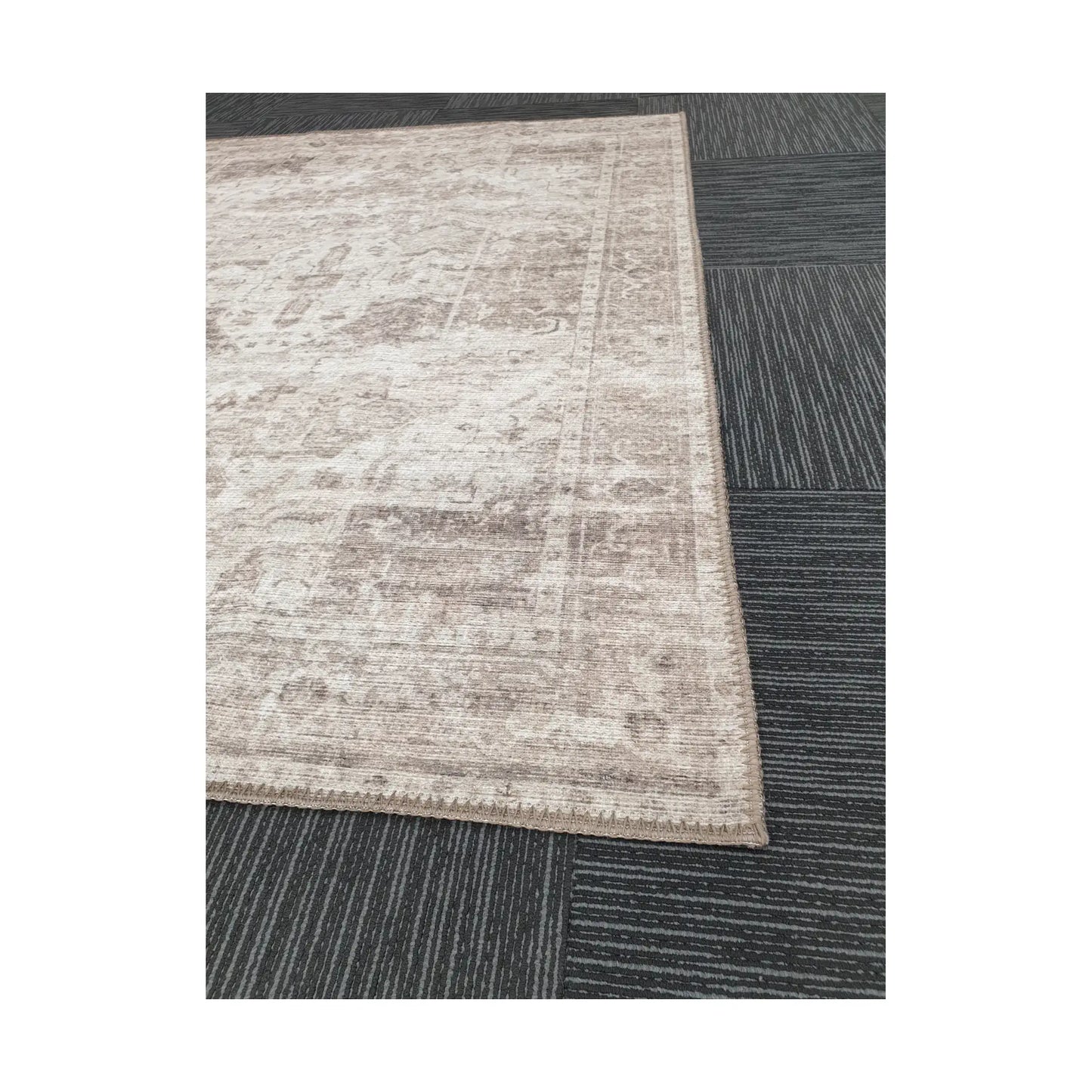 Close-up of ivory grey cotton rug corner with subtle ornamental border detail